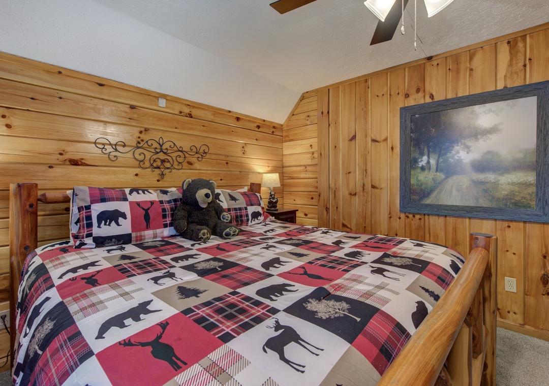 Snuggle into your rustic log cabin bedroom, where warm wood walls and cozy wildlife-themed bedding create the perfect mountain retreat atmosphere.