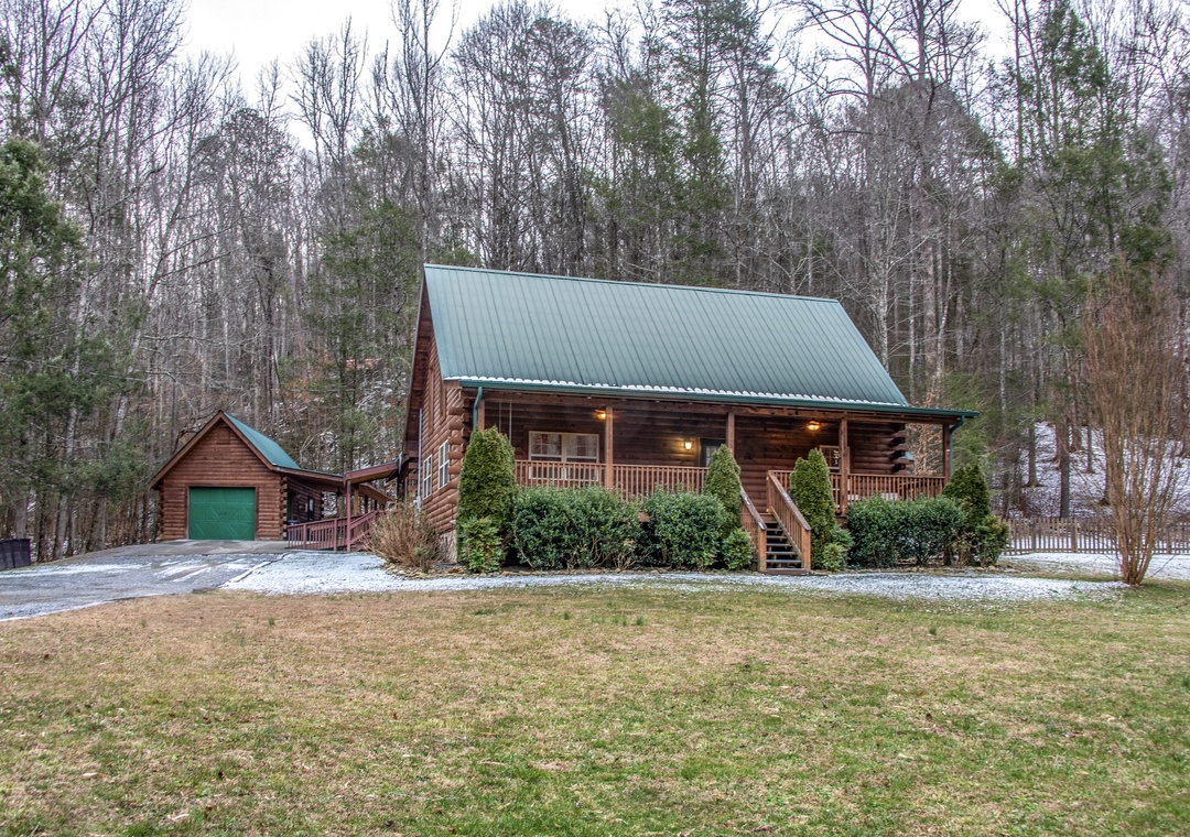 Charming log cabin nestled in wooded surroundings with spacious front porch and private driveway for a peaceful retreat.