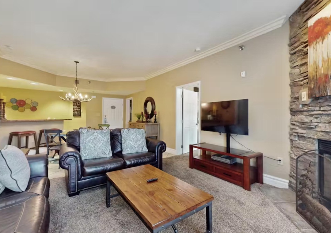 Unwind in your spacious living room with leather seating, cozy fireplace, and modern entertainment center for perfect relaxation.
