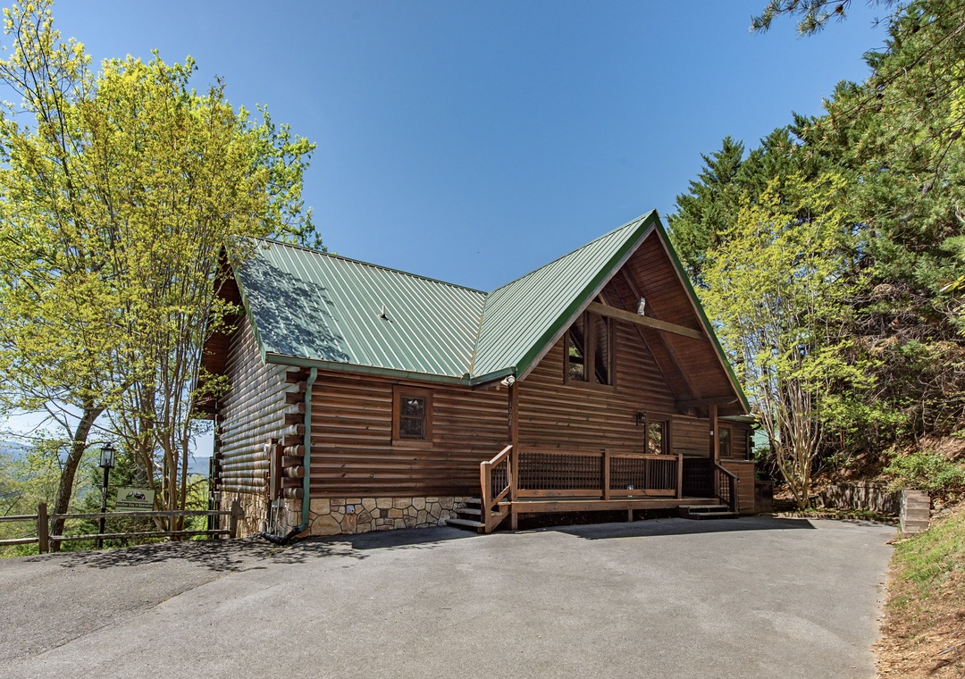 A rustic log cabin retreat nestled among towering trees with convenient paved parking and peaceful natural surroundings.