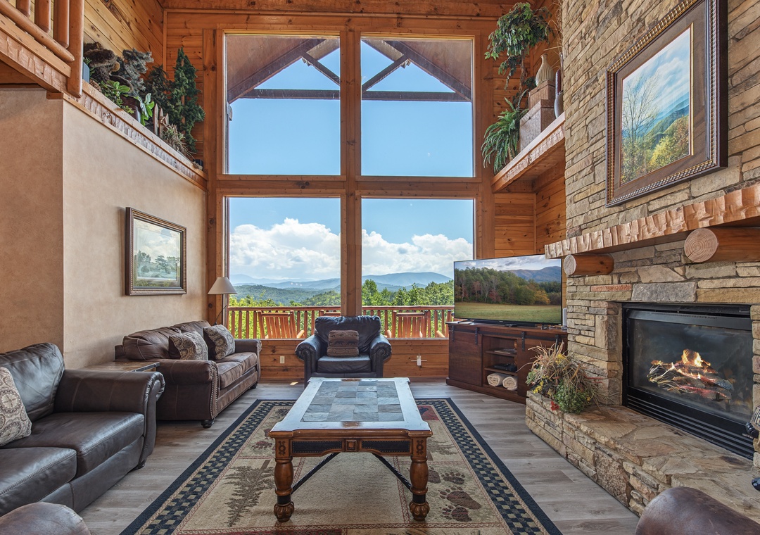 Unwind in this stunning living room where floor-to-ceiling windows frame breathtaking mountain vistas. Sink into plush leather seating by the stone fireplace and let the natural beauty surround you.