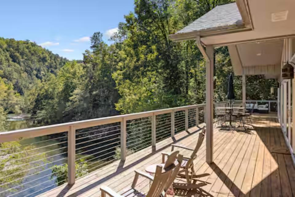 Unwind on your private deck with stunning river views through forested hills, complete with comfortable seating and outdoor dining space.