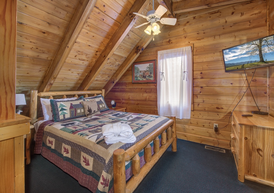 Cozy up in this charming log bedroom with rustic wooden beams and a handcrafted quilt, where mountain views await outside your window.
