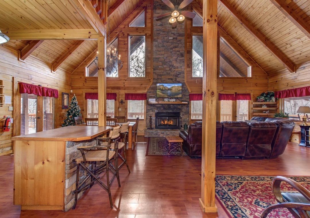Warm up by your stone fireplace in this stunning log cabin great room with soaring ceilings and rustic charm.