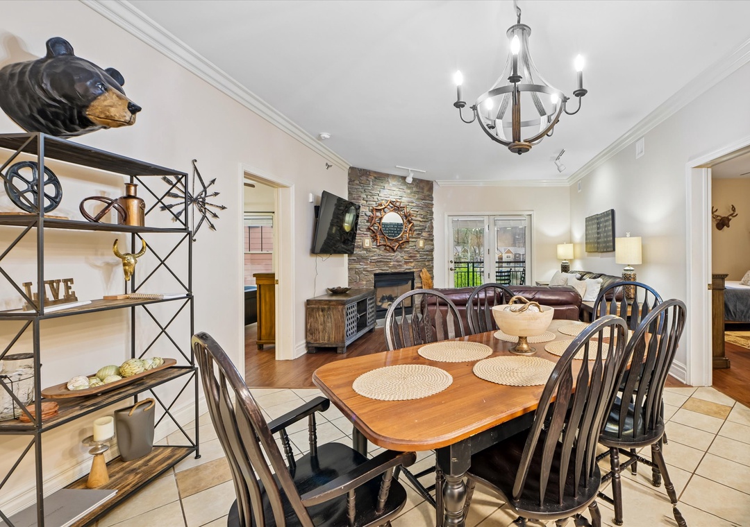 Your cozy dining space flows into a warm living area with stone fireplace, perfect for family meals and relaxing evenings together.