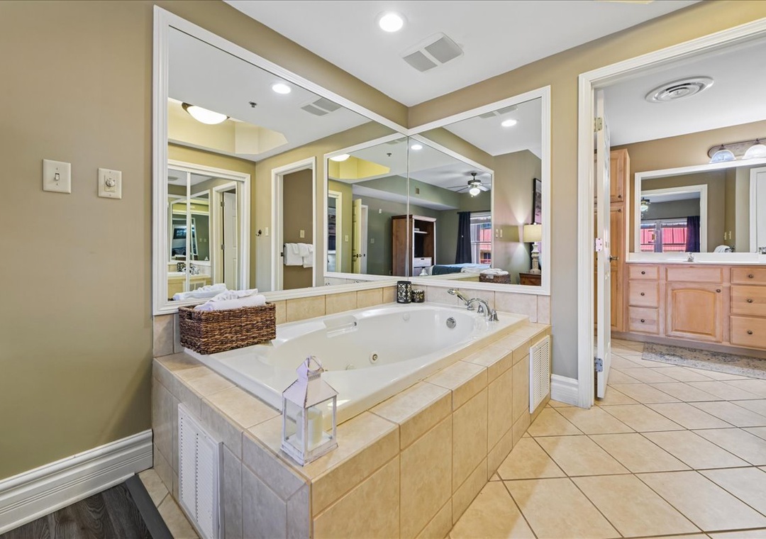 Unwind in your luxurious spa-style bathroom featuring a soaking tub surrounded by mirrors and elegant finishes for ultimate relaxation.