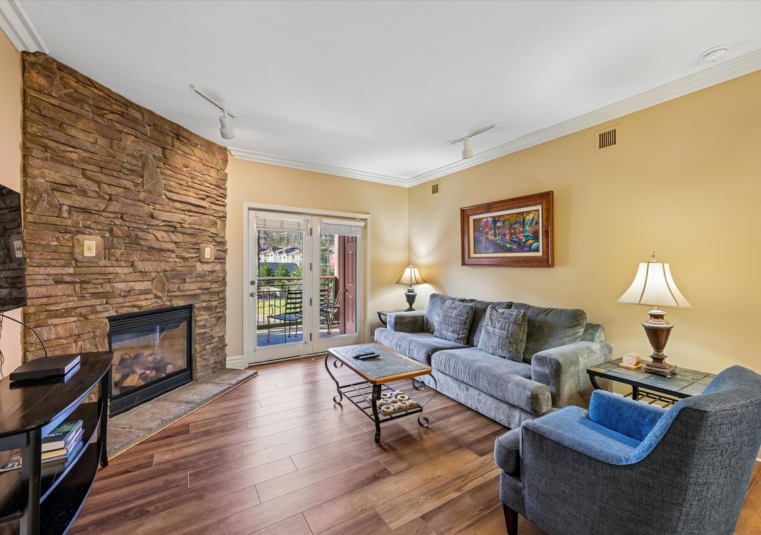 Unwind in your cozy living room with stone fireplace and plush seating, perfect for relaxing evenings.