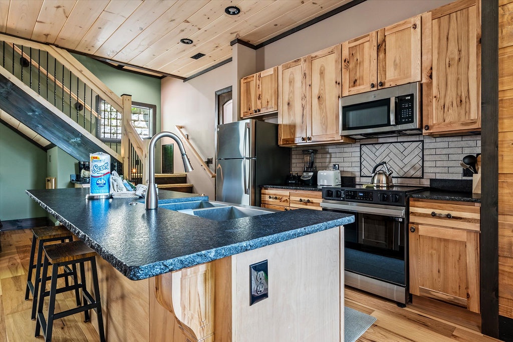 Your fully equipped kitchen awaits with modern appliances, sleek countertops, and charming wood cabinetry—perfect for preparing meals and gathering with loved ones in this inviting, open-concept space.