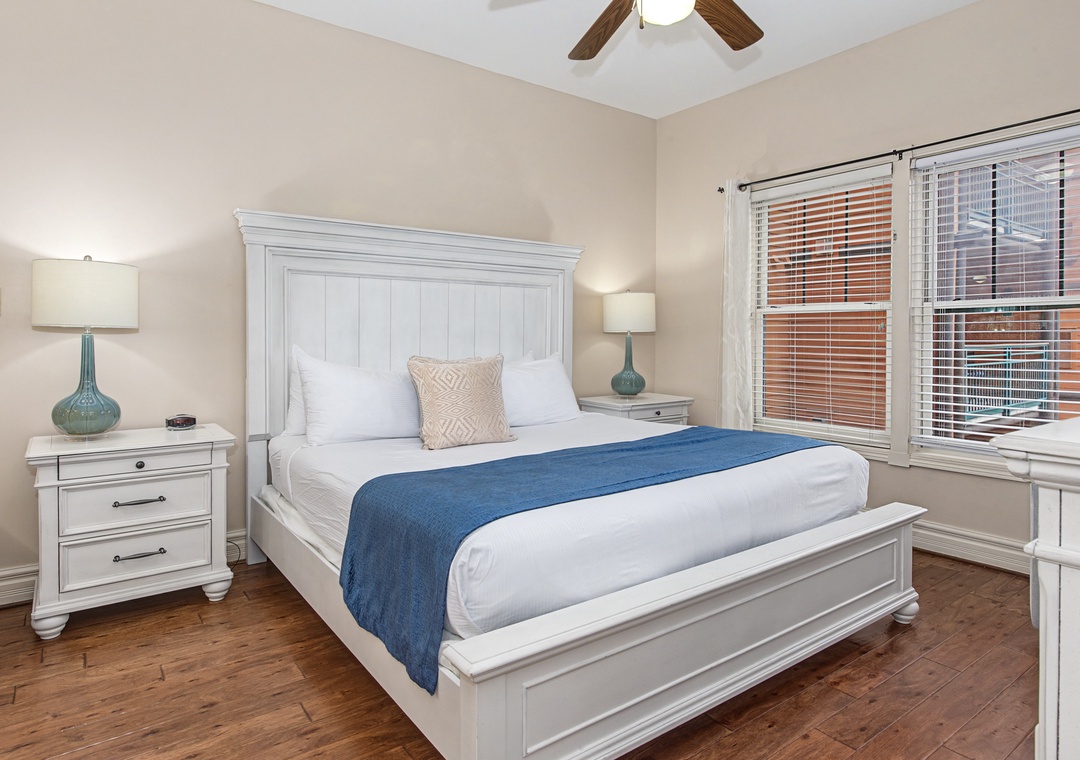 Unwind in your serene bedroom featuring a plush king bed, coastal-inspired decor, and warm hardwood floors for ultimate comfort.