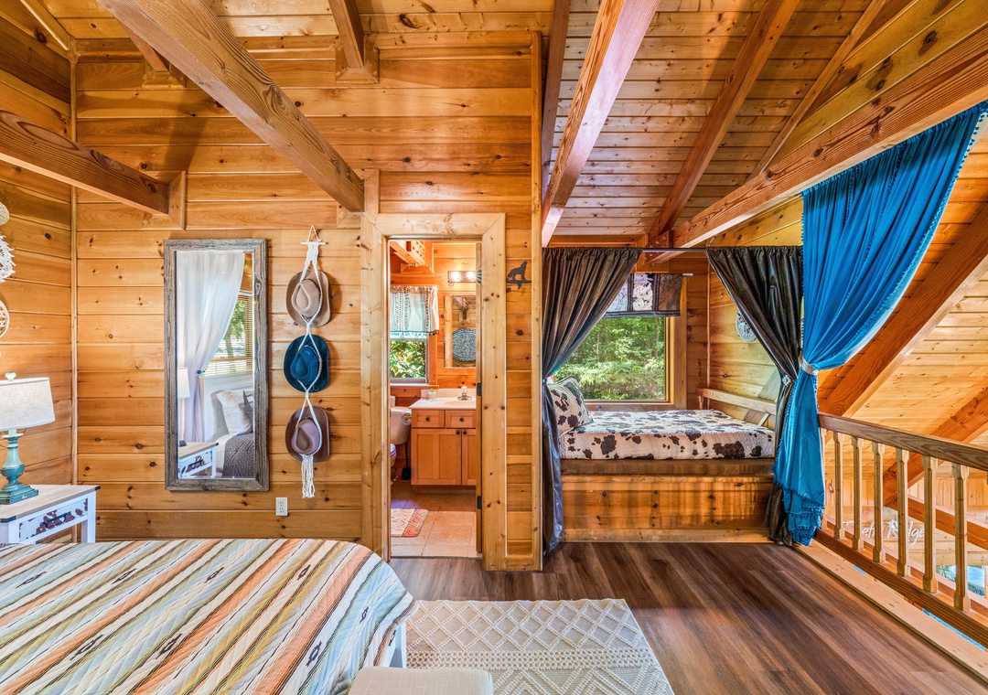 Drift off in this cozy loft, where warm wood beams frame two peaceful sleeping nooks with garden views and soft curtains—your private treehouse retreat.