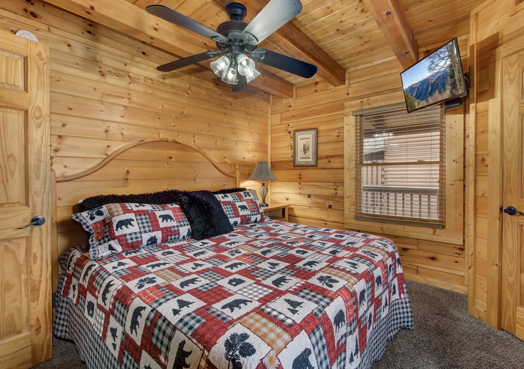 Cozy up in your rustic bedroom featuring warm log cabin walls, mountain views, and charming bear-themed bedding perfect for a peaceful night's rest.