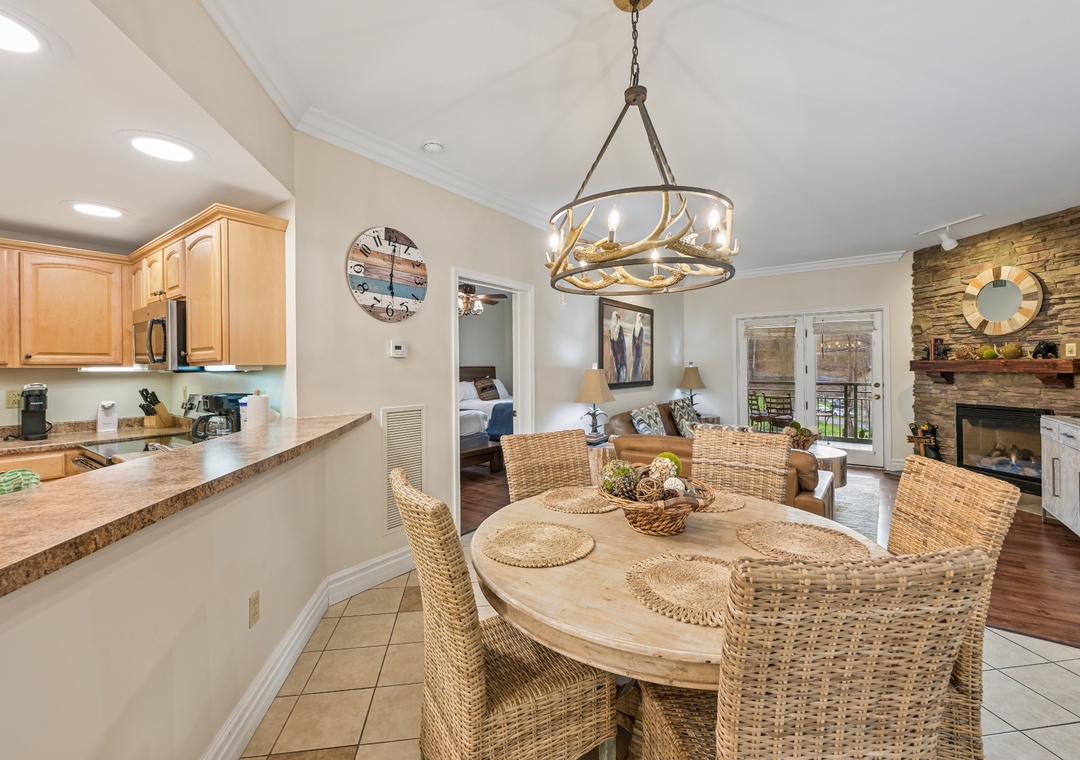 Your open-concept kitchen and dining area creates the perfect gathering space, with a cozy fireplace and natural wicker furnishings for memorable meals.