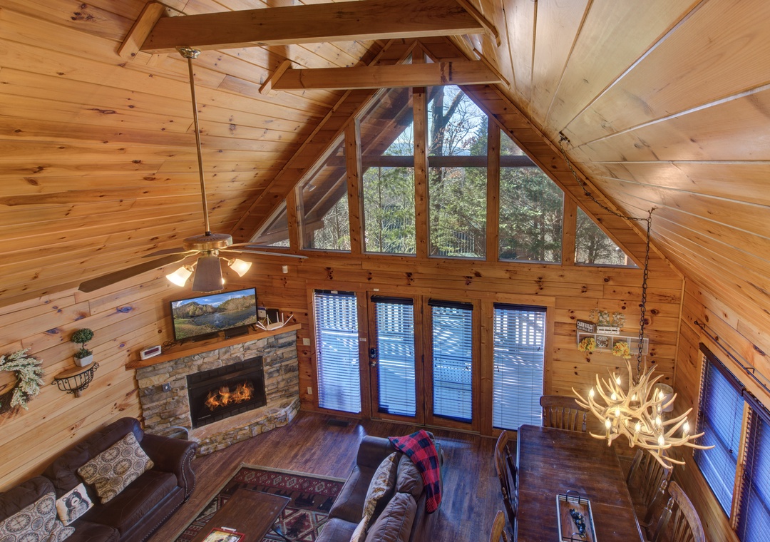Relax in this stunning log cabin with soaring ceilings, a cozy stone fireplace, and panoramic forest views from every window.