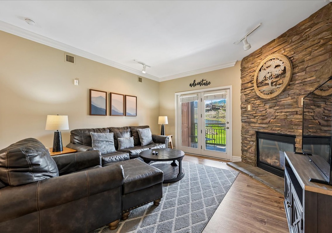 Sink into plush leather seating by your crackling fireplace, where rustic stone meets modern comfort for cozy evenings.