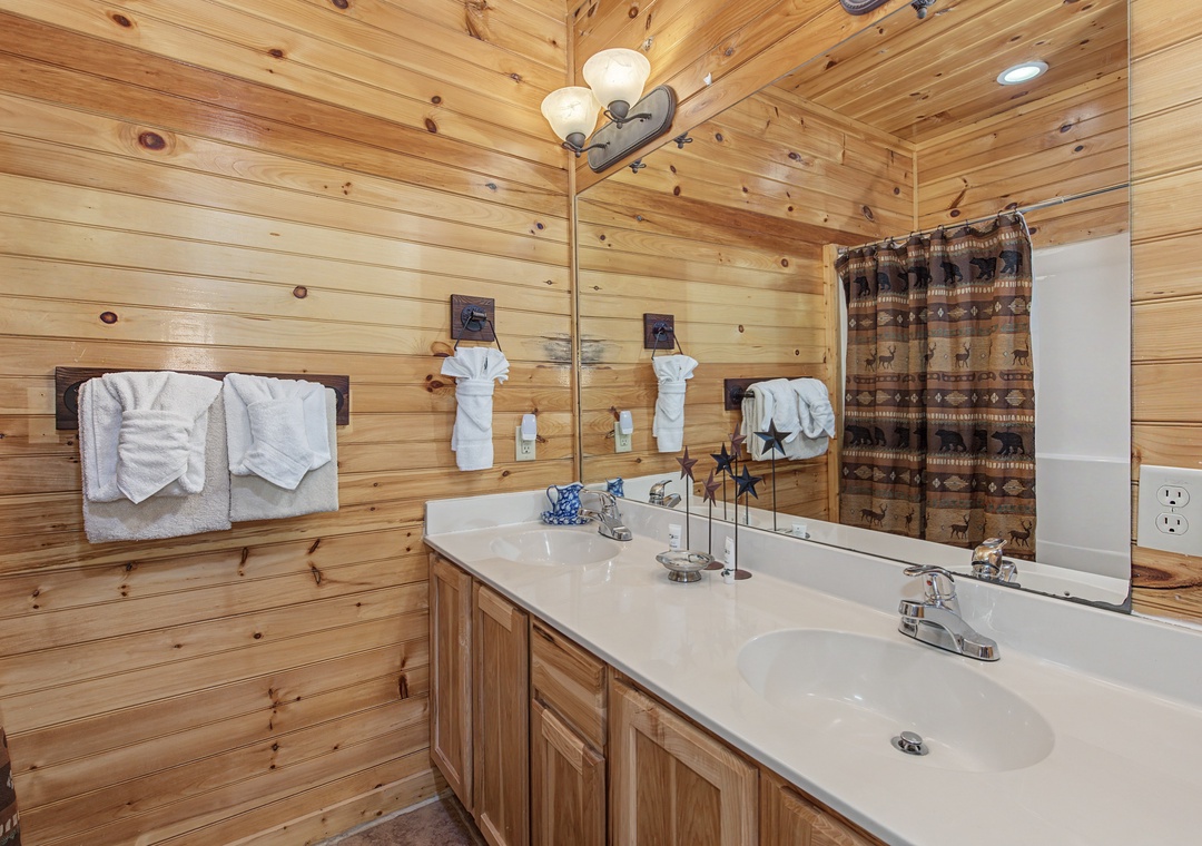 Warm wood paneling wraps around your private bathroom, creating a cozy cabin feel while you prepare for your mountain retreat.