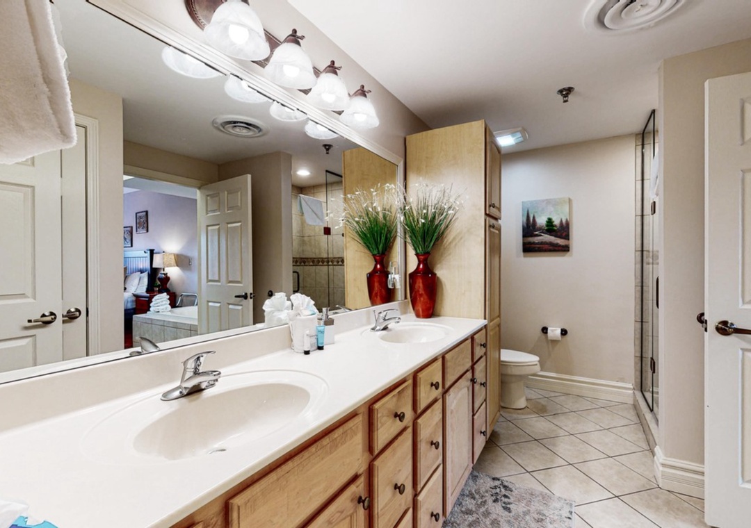Relax in your spacious bathroom with dual vanities, elegant decor, and thoughtful amenities for a comfortable stay.