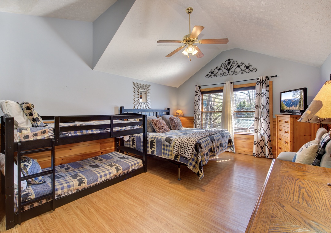 Unwind in your spacious bedroom featuring comfortable bunk beds and a double bed, perfect for family gatherings under soaring vaulted ceilings.