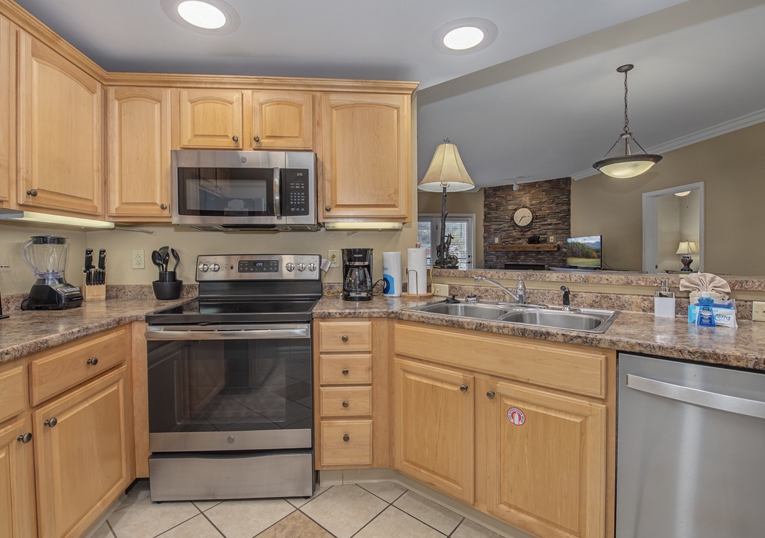 Cook your favorite meals in this fully equipped kitchen featuring granite countertops, modern appliances, and warm wood cabinetry.