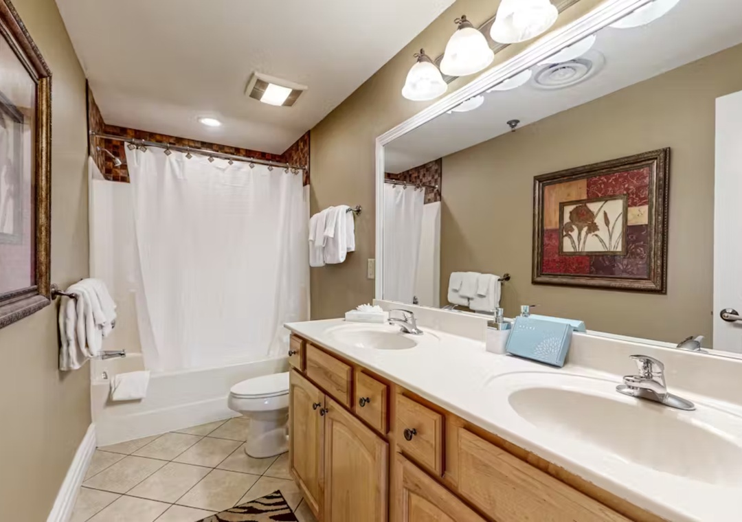 Your spacious bathroom features double sinks, a relaxing tub-shower combo, and warm lighting for your comfort.
