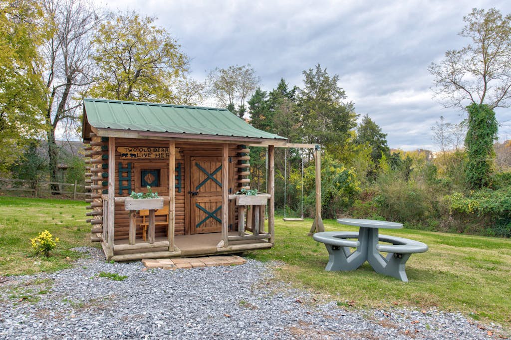 This charming log cabin playhouse sits on the property's spacious lawn, surrounded by lush trees and open green space—a delightful spot for little ones to imagine and explore during your stay.