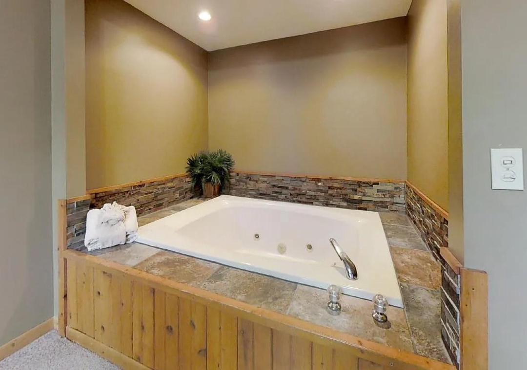 Unwind in your private jetted tub framed by warm stone accents and soft lighting—perfect for soothing soaks after adventurous days.
