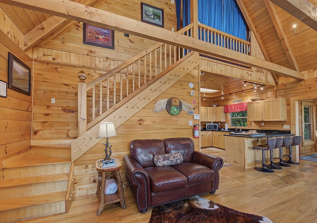 Imagine yourself relaxing in this cozy cabin with vaulted pine ceilings, a lofted upper level, and rich leather seating. The open-plan design connects your living space to a fully equipped kitchen, perfect for unwinding after exploring the area.