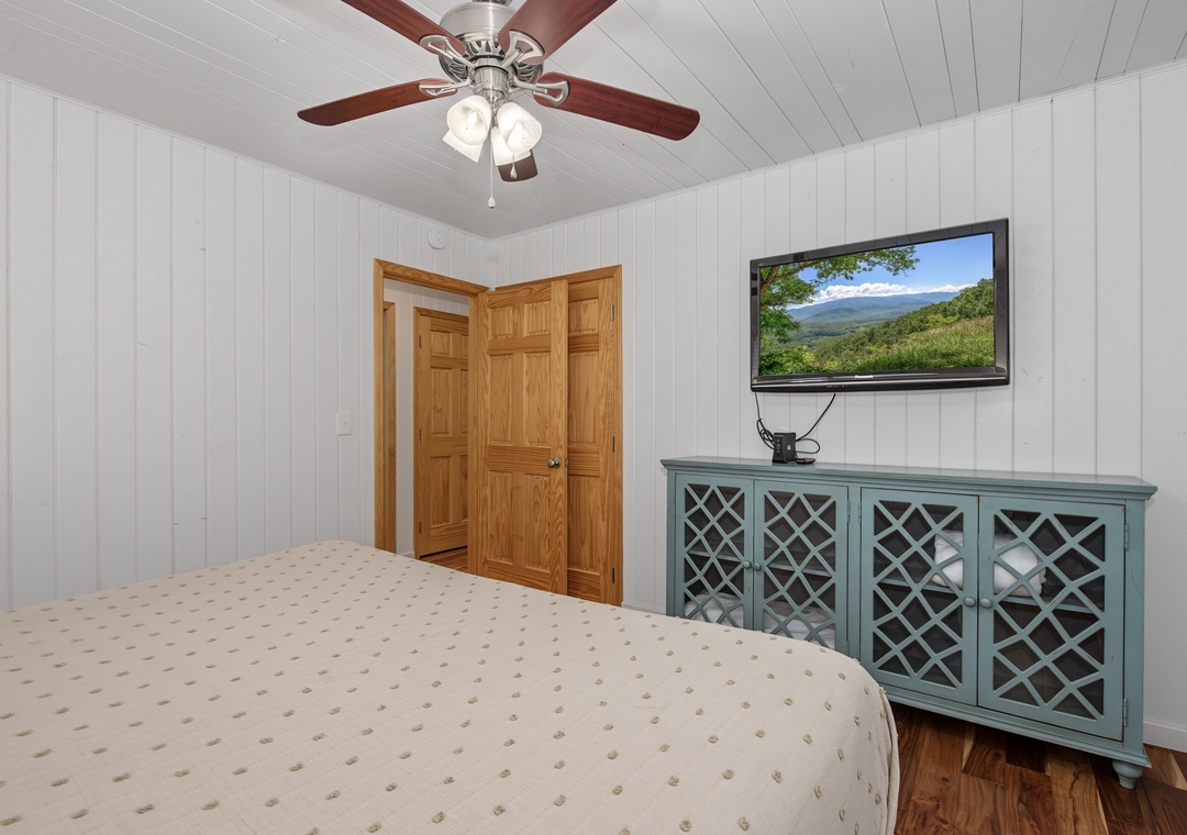 Unwind in your bright bedroom with vaulted ceilings, a ceiling fan to keep you cool, and charming cottage details like the paneled walls and lovely green chest where you can watch your favorite shows.