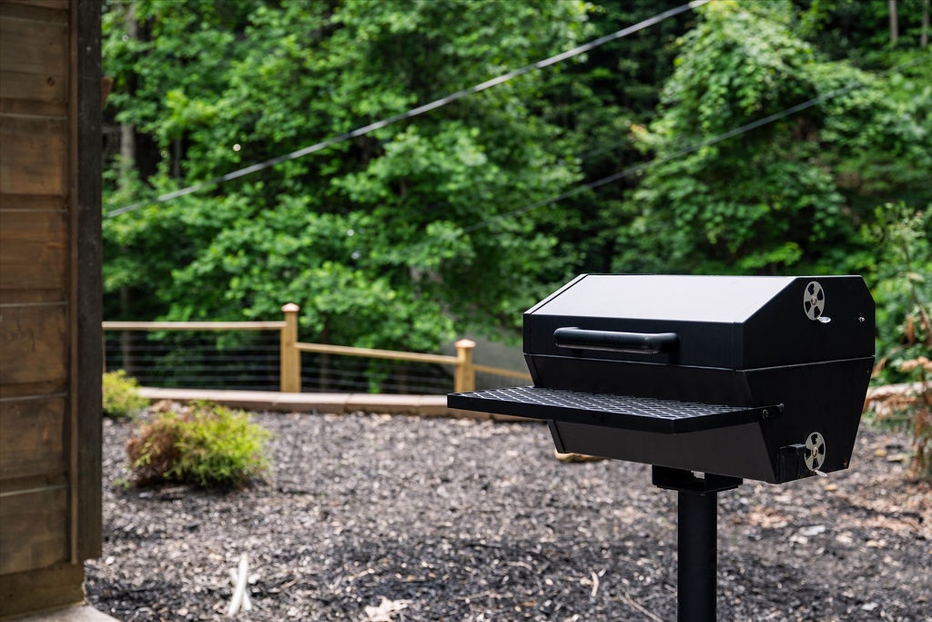 Fire up your own outdoor feast with a sleek, ready-to-use grill set against a peaceful forest backdrop, perfect for memorable cookouts.