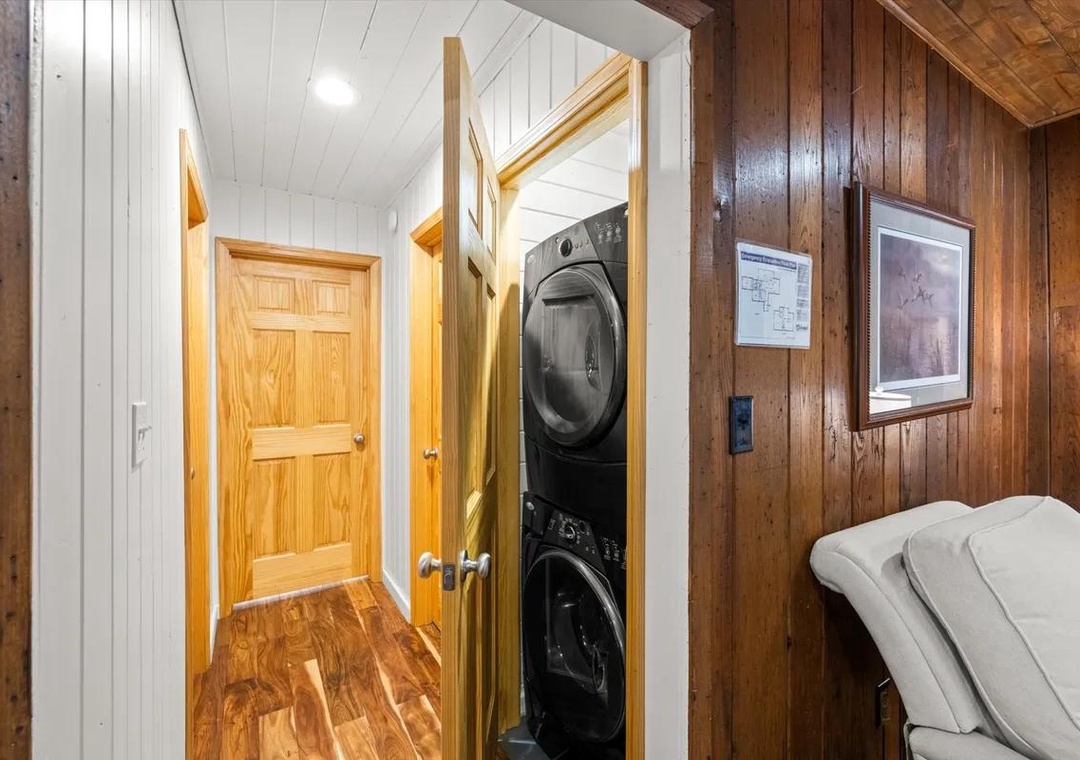 Your cozy cabin-style retreat includes modern conveniences like in-unit laundry, tucked neatly into a closet off the hallway. Warm wood tones and cottage charm meet practical comfort here.