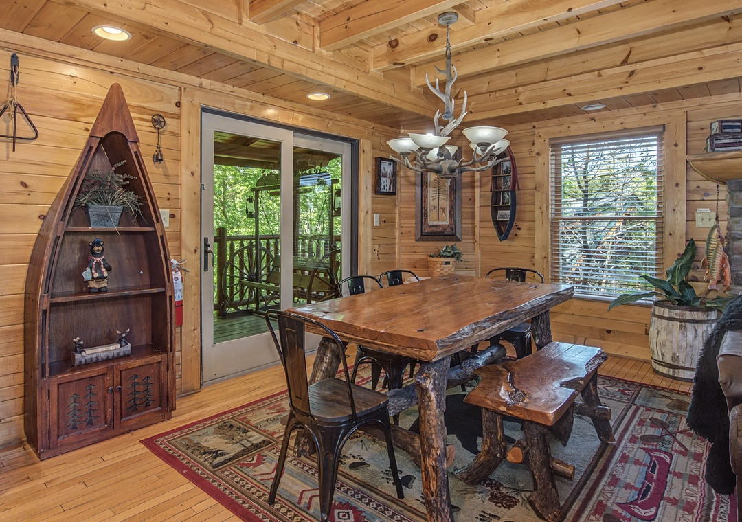 Gather around your rustic dining table under the antler chandelier, where warm wood surrounds you and forest views invite memorable meals.