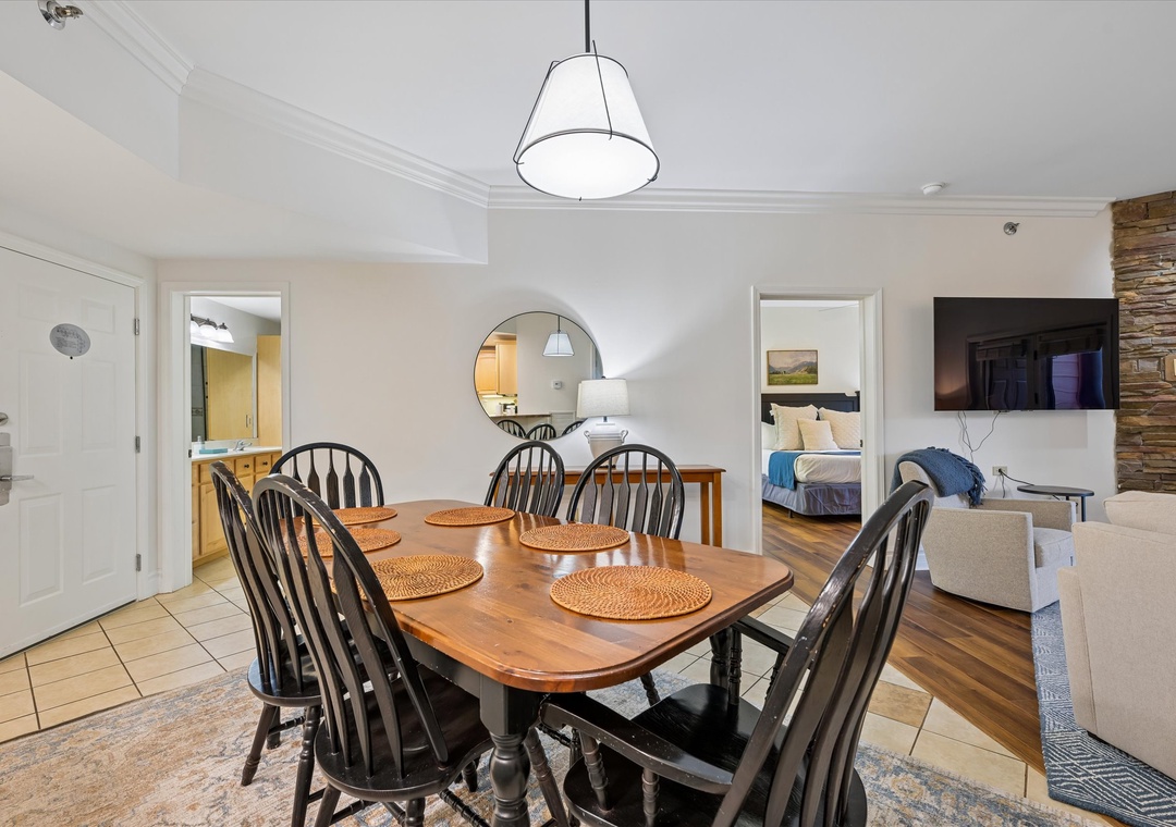 Your spacious dining area welcomes memorable meals with a beautiful wooden table set for eight, perfect for family gatherings and conversations.