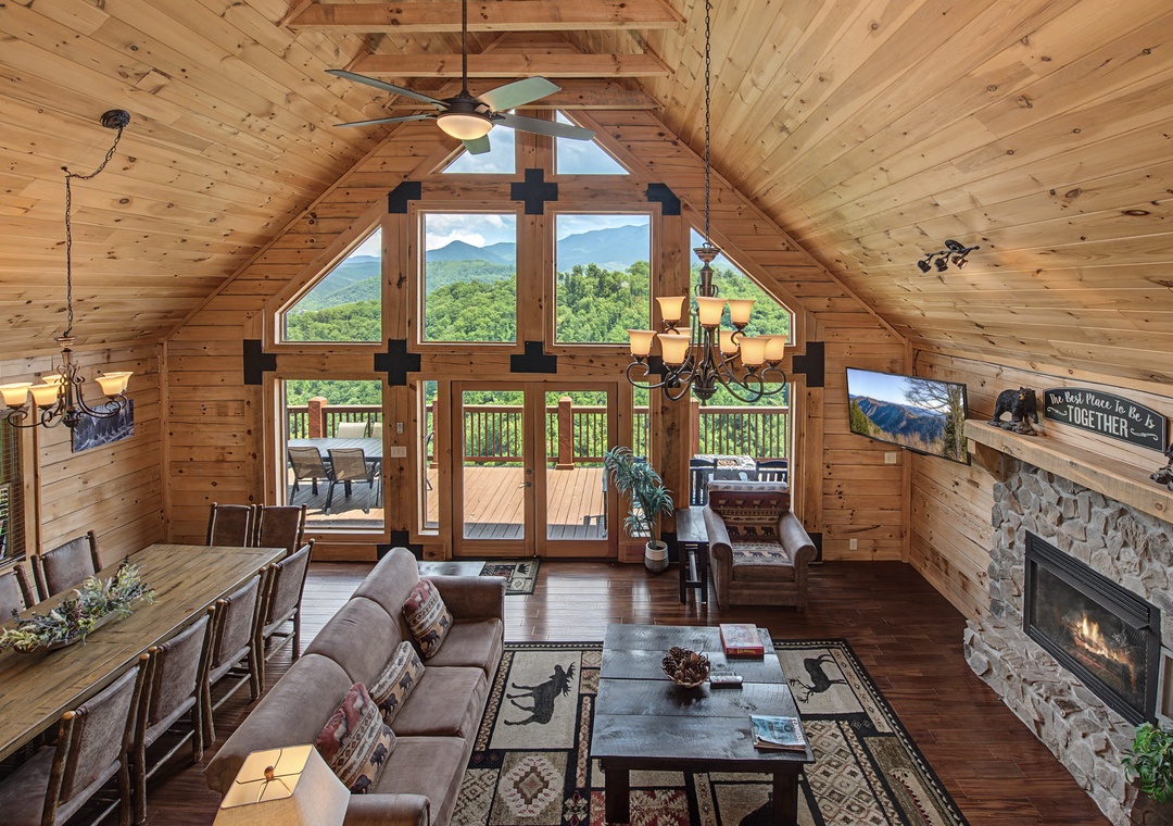 Soaring ceilings and floor-to-ceiling windows frame stunning mountain vistas in this warm, wood-lined great room where you'll gather by the stone fireplace after adventure-filled days.