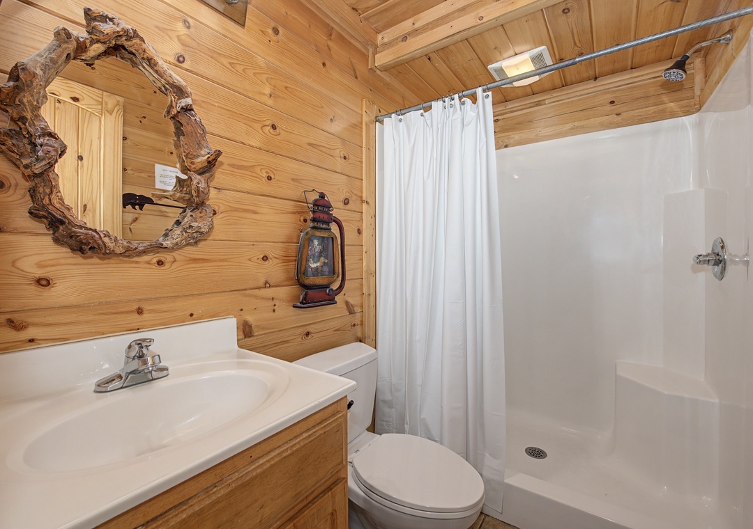Step into your rustic bathroom sanctuary with warm wood walls, clean white fixtures, and charming cabin decor that makes you feel right at home.