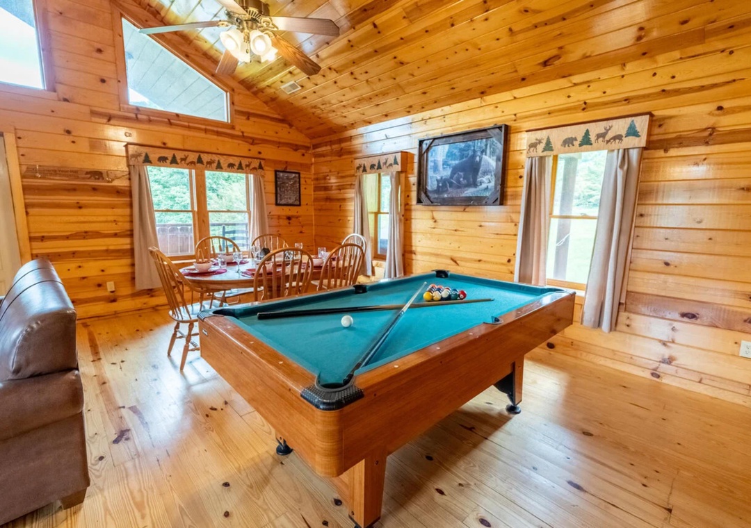 Gather for games and meals in your spacious cabin retreat with warm wood interiors, a pool table, dining area, and mountain-themed touches throughout.