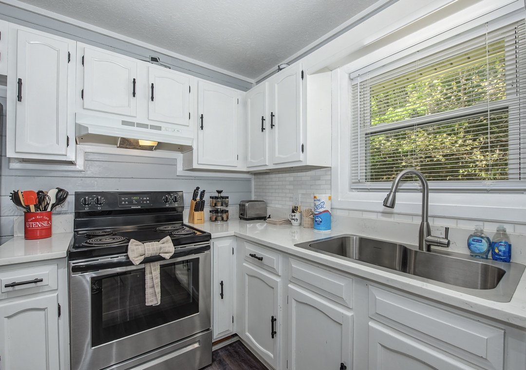 Your fully equipped kitchen features crisp white cabinets, stainless steel appliances, and everything you need for home-cooked meals.