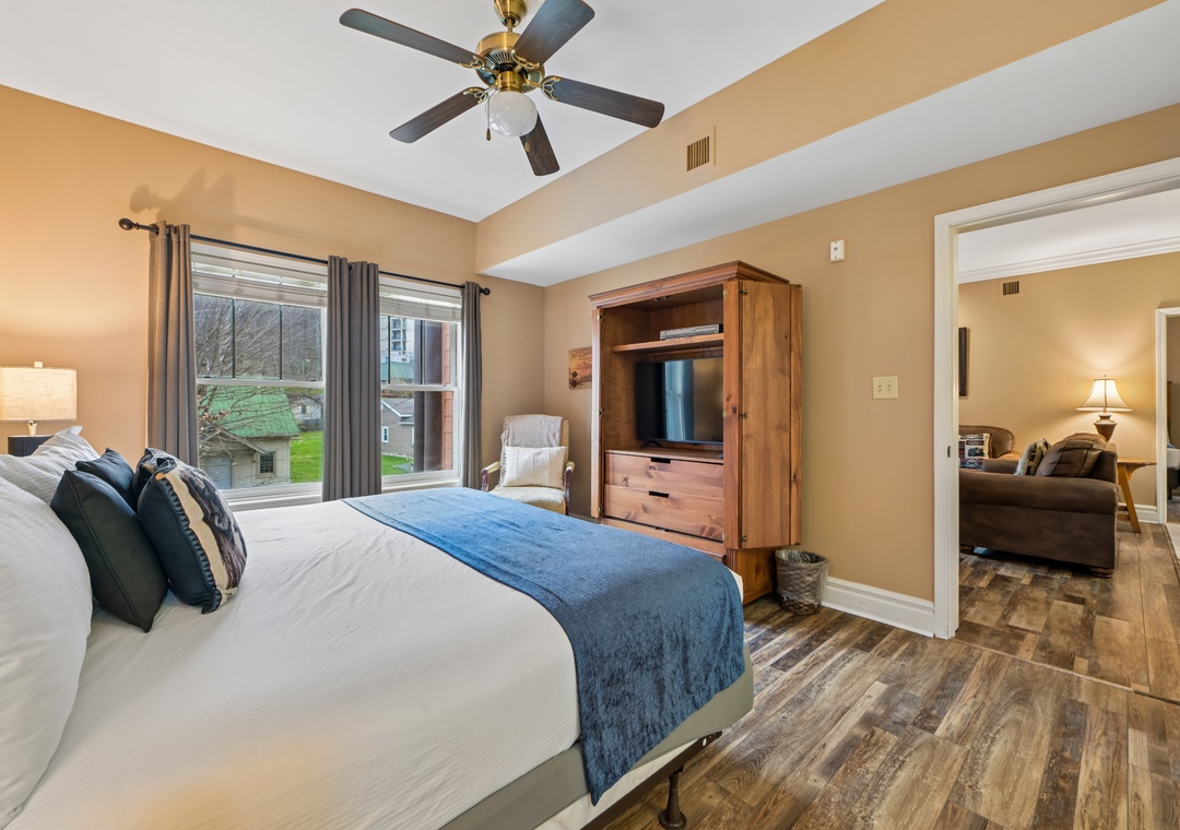 Relax in your spacious bedroom with plush bedding, ceiling fan, and entertainment center while enjoying views of the peaceful neighborhood.