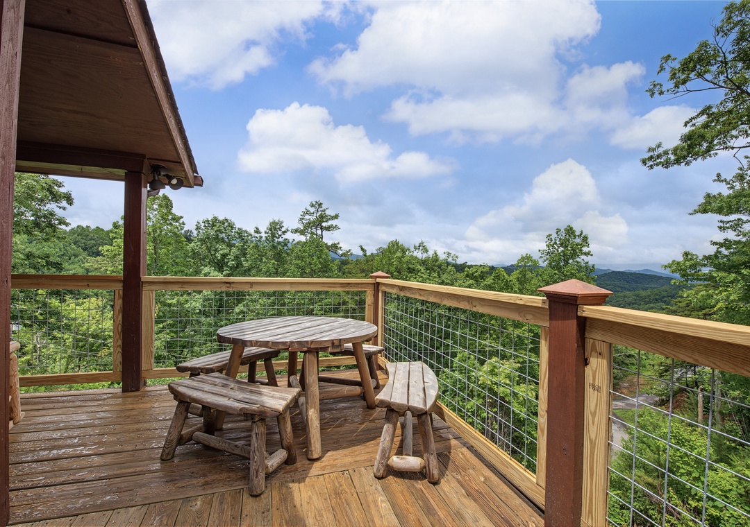 Sip morning coffee at this rustic outdoor table while taking in sweeping mountain and forest views from your private deck surrounded by nature's tranquility.