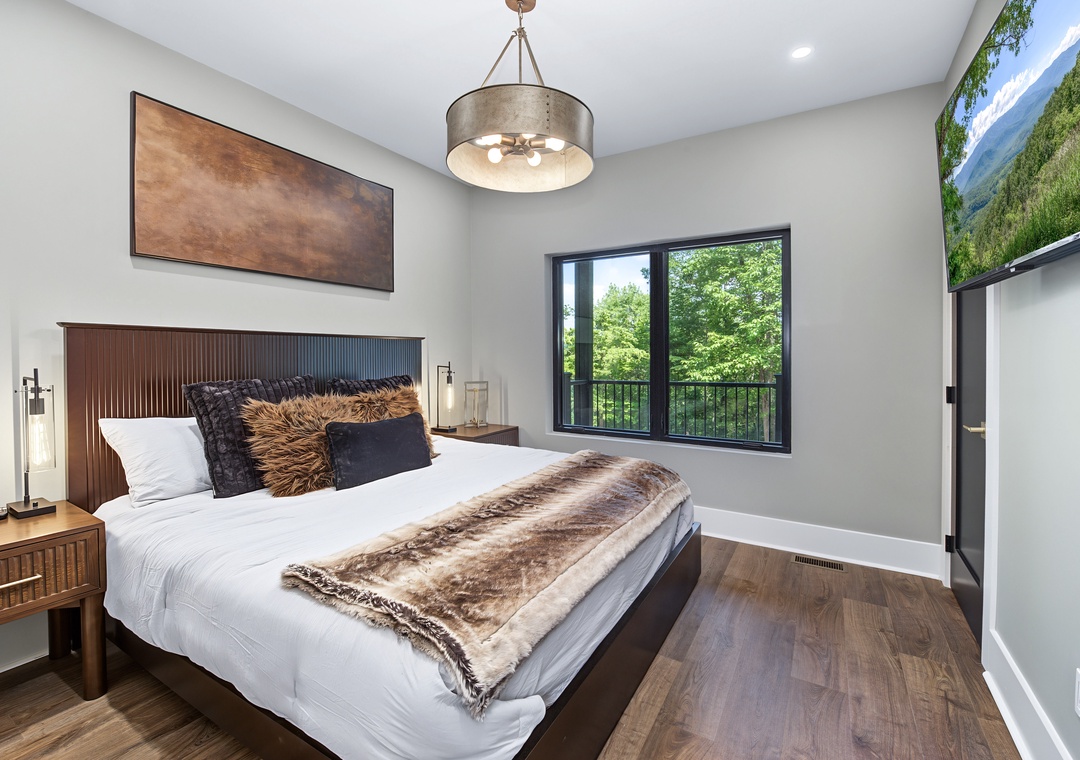 Sink into plush bedding and wake to serene garden views framed by modern windows. Your private retreat features elegant lighting, cozy textures, and rich wood tones that invite total relaxation.