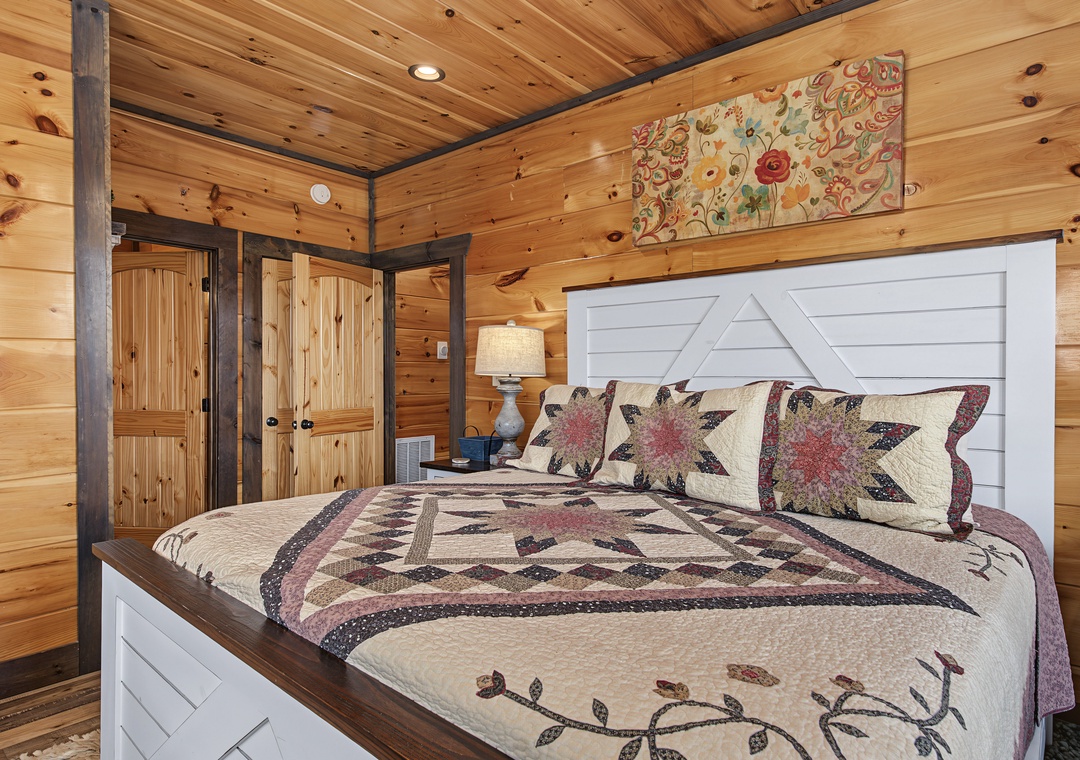 Drift off in this cozy bedroom where rustic pine walls meet charming farmhouse details. Your plush quilt and handcrafted headboard promise restful nights after mountain adventures.