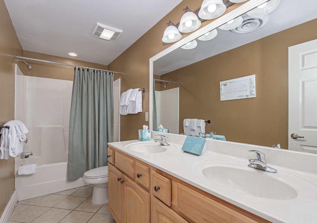 Refresh in your spacious bathroom featuring a dual-sink vanity, relaxing soaking tub, and thoughtful amenities for your comfort.