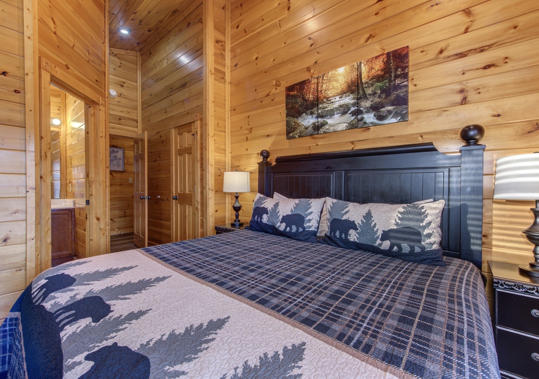 Drift off in your cozy cabin bedroom, where warm wood-paneled walls and plush bedding create the perfect mountain retreat after a day of adventure.