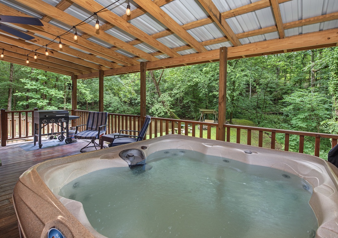 Slip into your private hot tub surrounded by lush forest views. String lights overhead set the mood while you unwind with the soothing sounds of nature all around.