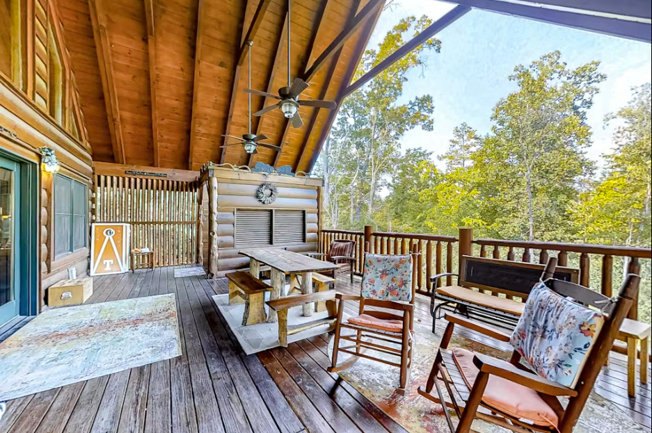 Your private covered deck offers peaceful forest views with comfortable seating and rustic charm for morning coffee or evening relaxation.