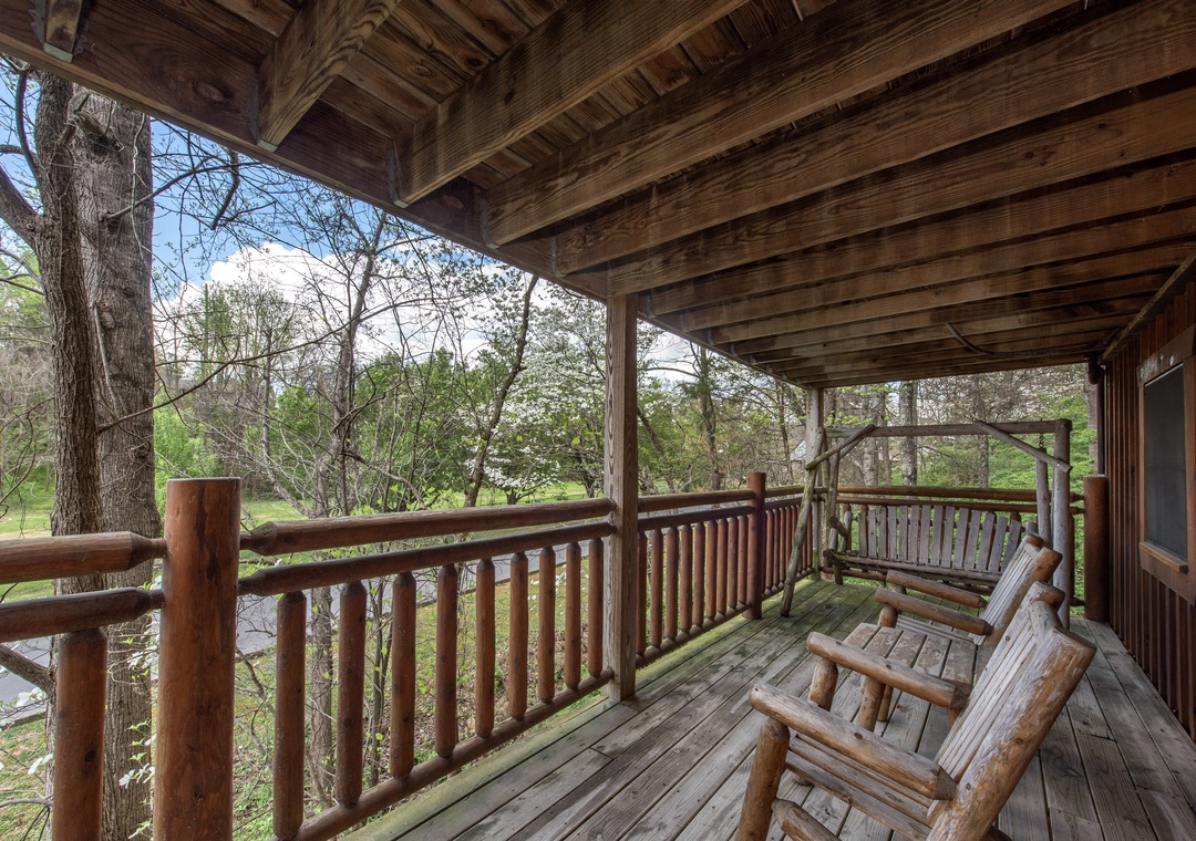 Unwind on your private covered deck with handcrafted log furniture while soaking in peaceful forest views through towering trees.