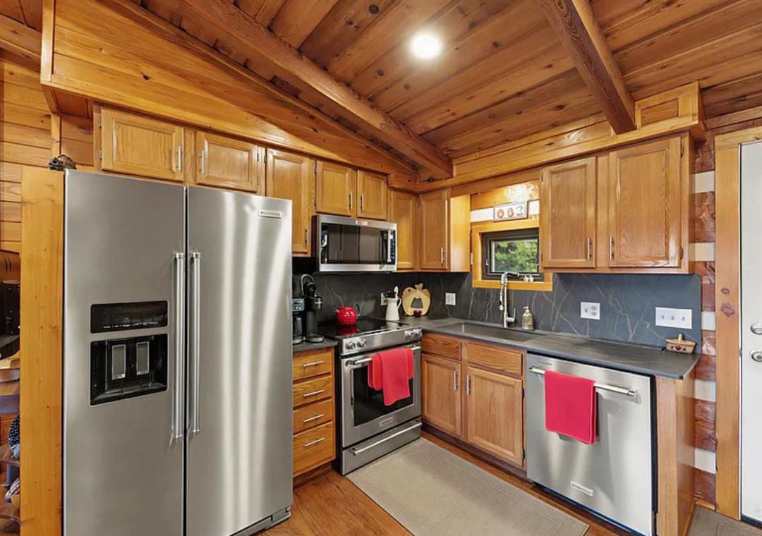 Picture yourself cooking up your favorite meals in this beautifully equipped kitchen, with its warm wood finishes, modern stainless appliances, and all the space you need to feel right at home.