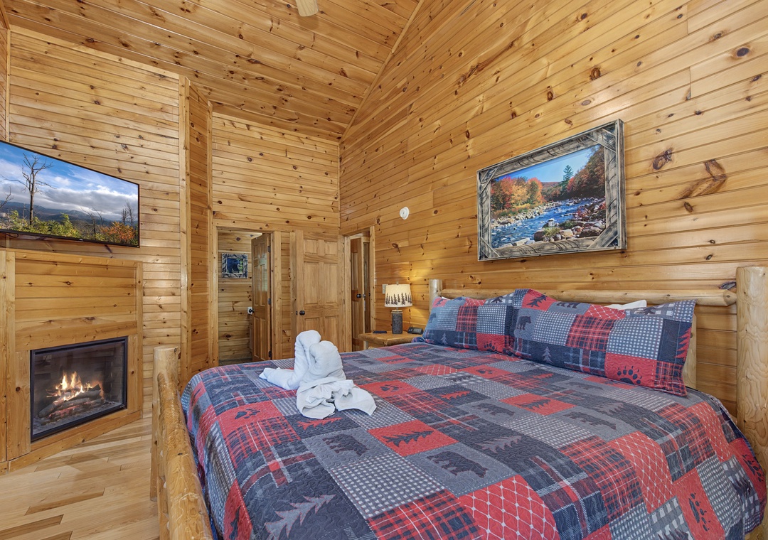 Cozy up in your rustic bedroom with a fireplace and plaid bedding that screams mountain retreat comfort.