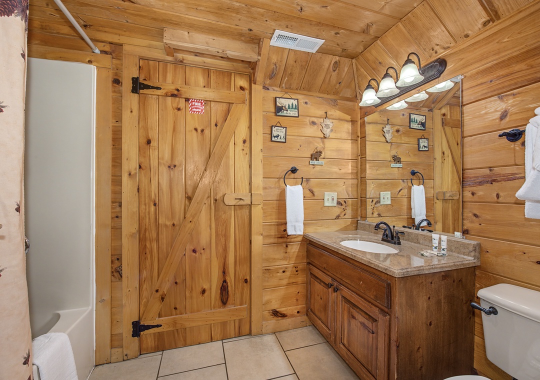 Step into your rustic bathroom retreat with warm wood walls, granite vanity, and charming cabin details that make getting ready feel special.