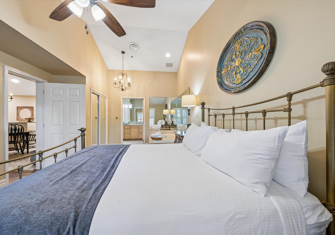 Drift off in your elegant brass bed beneath soaring ceilings, where Mediterranean charm meets modern comfort in this spacious master suite.