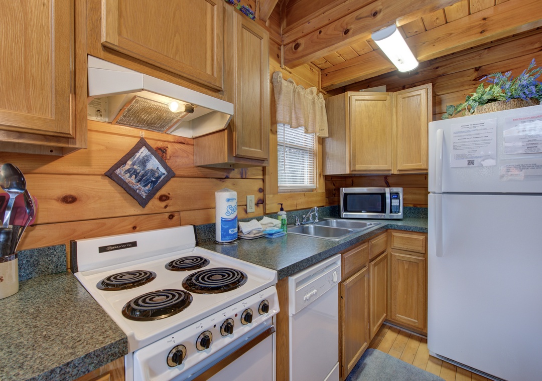 Your cozy cabin kitchen features everything you need: full appliances, granite counters, and rustic wood charm for memorable meals.