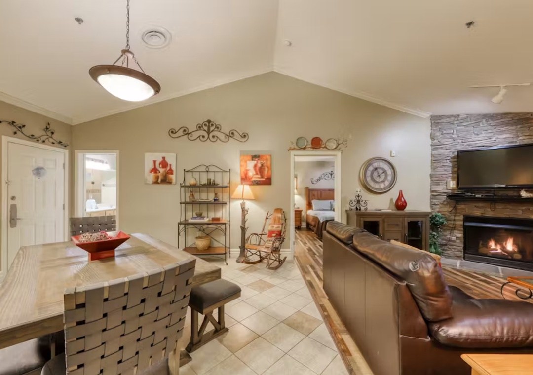 Unwind in your spacious living area where leather seating and a crackling fireplace create the perfect atmosphere for cozy evenings together.